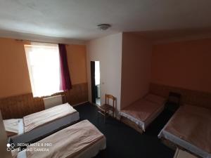 um quarto com três camas e uma janela em Penzion u Jakuba em Svoboda nad Úpou