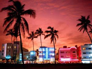 une ville de nuit avec des palmiers et des bâtiments dans l'établissement APARTMENT RIGHT ON THE BEACH!, à Miami Beach