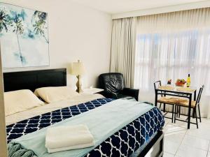 a bedroom with a bed and a table with a chair at APARTMENT RIGHT ON THE BEACH! in Miami Beach