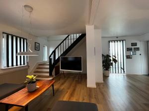 un salon avec une télévision et un escalier dans l'établissement Cozy Holeby House Close to Puttgarden & Femern, à Holeby