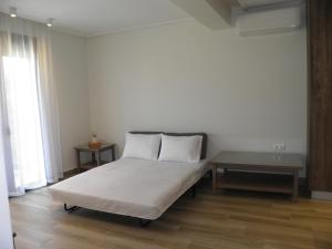 a bed with two pillows and a table in a room at Anemolia Elegant Apartment in Karistos