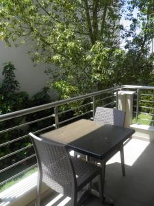 een zwarte tafel en 2 stoelen op een balkon bij Anemolia Elegant Apartment in Karistos