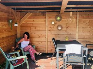 une femme assise dans une chaise dans une cabine dans l'établissement Chalet Kocky, à Midsland