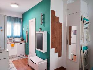 a kitchen with green walls and a white refrigerator at Bright and quiet studio in Málaga in Málaga