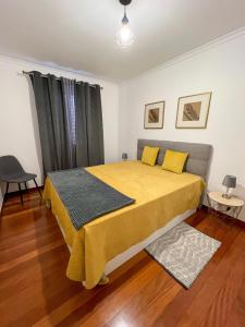 a bedroom with a bed with yellow sheets and yellow pillows at The Pink Villa in Caniço