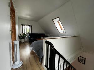 Pokój na poddaszu z łóżkiem i klatką schodową w obiekcie Cozy Holeby House Close to Puttgarden & Femern w mieście Holeby