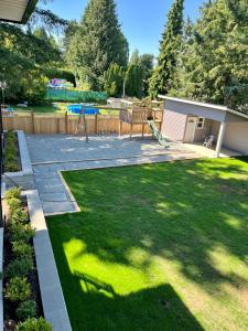 a yard with green grass and a playground at Brand New 2BR Suite with Mini Golf, Children Play Area, and Stunning Patio in Aldergrove in Aldergrove