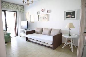 a living room with a couch and a tv at By the sea in Nikiana