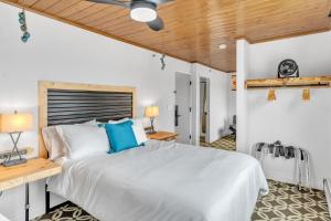 a bedroom with a white bed and a wooden ceiling at Highliner Hotel - Deluxe Double Queen with Mountain View in Anchorage