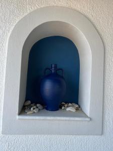 um vaso azul sentado numa prateleira numa parede em pirgaki seaside house em Naxos Chora