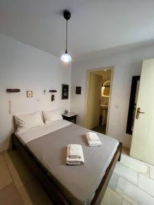 a bedroom with a large bed with two towels on it at pirgaki seaside house in Naxos Chora