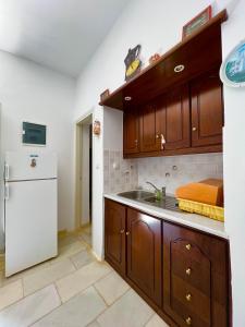 eine Küche mit Holzschränken und einem weißen Kühlschrank in der Unterkunft pirgaki seaside house in Naxos Chora