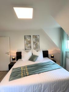 a bedroom with a large white bed with two lamps at 3Room-Central-Modern near MTU- The Zeppelin by Lakescape FeWos in Friedrichshafen