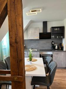 a kitchen with a white table with chairs and a stove at 3Room-Central-Modern near MTU- The Zeppelin by Lakescape FeWos in Friedrichshafen