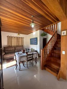 a living room with a table and a staircase at Raio de Sol na Montanha in Campos do Jordão