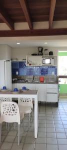 a kitchen with a white table and chairs in it at Ancorar Flat in Porto De Galinhas