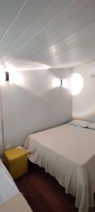 una habitación con 2 camas y una caja amarilla entre ellas en Ancorar Flat, en Porto de Galinhas