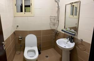 a small bathroom with a toilet and a sink at 2 Bedrooms Apartment in Makkah in Makkah