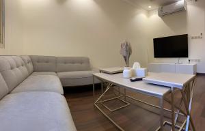 a living room with a couch and a table with a tv at 2 Bedrooms Apartment in Makkah in Makkah