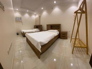 麥加的住宿－2 Bedrooms Apartment in Makkah，一间设有两张床的客房,墙上挂着一幅画