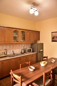 a kitchen with a wooden table and a refrigerator at Vila Visi Hotel in Korçë