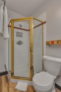 a bathroom with a shower and a white toilet at Highliner Hotel - Queen Suites in Anchorage