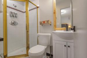 a bathroom with a toilet and a sink and a shower at Highliner Hotel - Queen Suites in Anchorage
