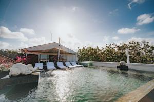 a pool with chaise lounge chairs and a swimming pool at Allia Residence in Nusa Dua