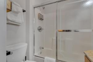 uma casa de banho branca com um chuveiro e um WC. em Highliner Hotel - Deluxe King with City View em Anchorage
