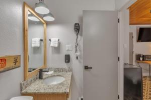 een badkamer met een wastafel en een spiegel bij Highliner Hotel - Deluxe Interior King Rooms- No View in Anchorage