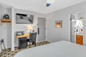 een slaapkamer met een bed en een bureau met een computer bij Highliner Hotel - Deluxe Interior King Rooms- No View in Anchorage