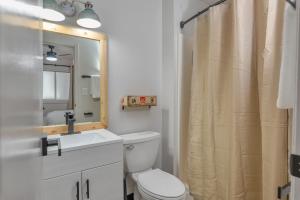 a bathroom with a toilet and a sink and a mirror at Highliner Hotel - Deluxe Interior King Rooms- No View in Anchorage
