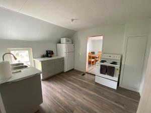 a kitchen with white appliances and a wooden floor at The Water Street Inn in Napanee