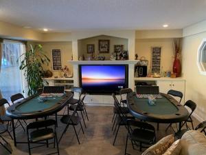a living room with two tables and a large television at Dragonfly Inn Walkout Suites in Sherwood Park