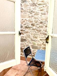 a blue chair sitting next to a stone wall at Loft Porta da Vila in Noya