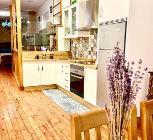 a kitchen with white appliances and a wooden floor at Loft Porta da Vila in Noya