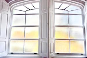 an open window with four windows in a room at Loft Porta da Vila in Noya