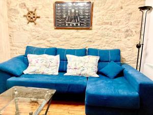 a blue couch with pillows in a living room at Loft Porta da Vila in Noya +3 photos