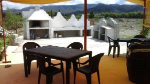 - une table et des chaises assises sous un parasol sur une terrasse dans l'établissement Sa Stella E Monti, à Marrùbiu