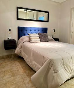 a bedroom with a large bed with a blue headboard at Paramont Rosario 1 in Rosario de la Frontera