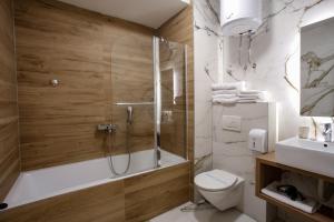 a bathroom with a shower and a toilet and a sink at Hotel Emen in Mostar