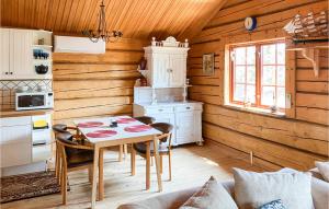 una cocina con mesa y sillas en una cabaña en Stunning Home In Figeholm With Kitchen, en Figeholm