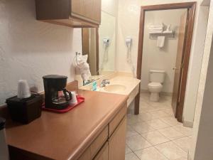 a bathroom with a sink and a toilet at Red Carpet Inn Medford in Medford +26 photos