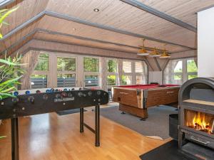 a living room with a pool table and a fireplace at 14 person holiday home in R m in Kongsmark