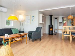 a living room with a couch and a table and a stove at Holiday home Hejls LVI in Hejls