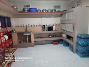 a small kitchen with a sink and a microwave at Sunapur Mini Resort Sylhet in Sylhet