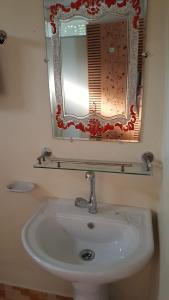 een badkamer met een witte wastafel en een spiegel bij Sunapur Mini Resort Sylhet in Sylhet