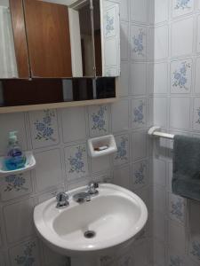 y baño con lavabo y espejo. en Departamento Parque España en Rosario