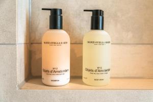 zwei Flaschen mit antiseptischem Nebel auf einem Regal in der Unterkunft BNBNRD Stylish Boutique Apartment 45m2 w Panoramic Views - private entrance in Amsterdam + 16 Fotos