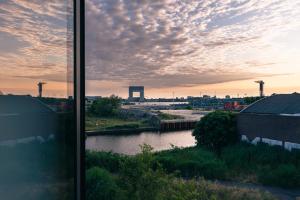 Blick auf einen Fluss aus einem Fenster einer Stadt in der Unterkunft BNBNRD Stylish Boutique Apartment 45m2 w Panoramic Views - private entrance in Amsterdam